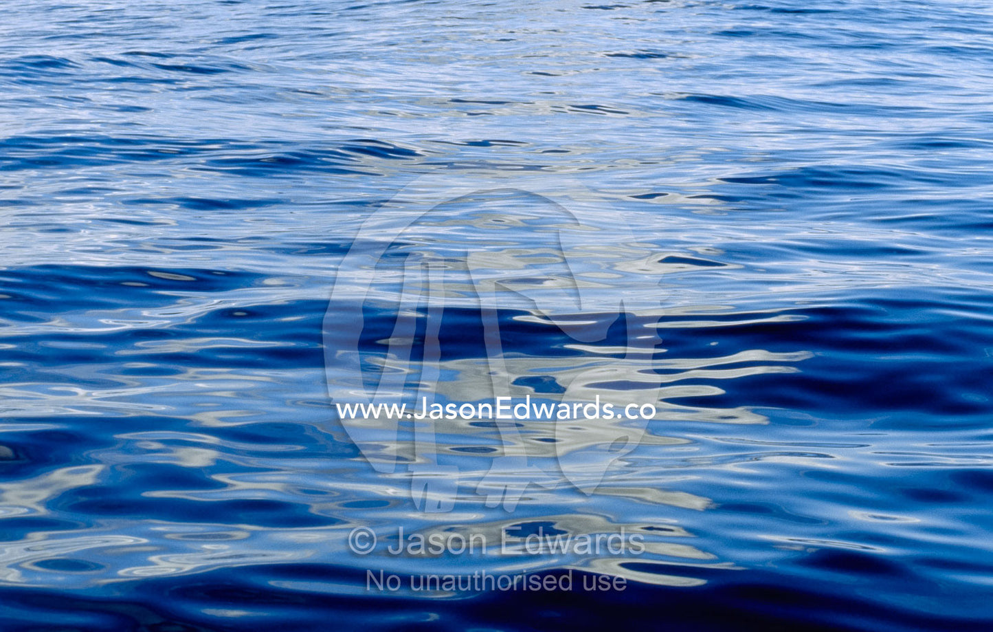 Reflections create abstract patterns on the surface of a calm sea. Continental Shelf off Eden, New South Wales, Australia.