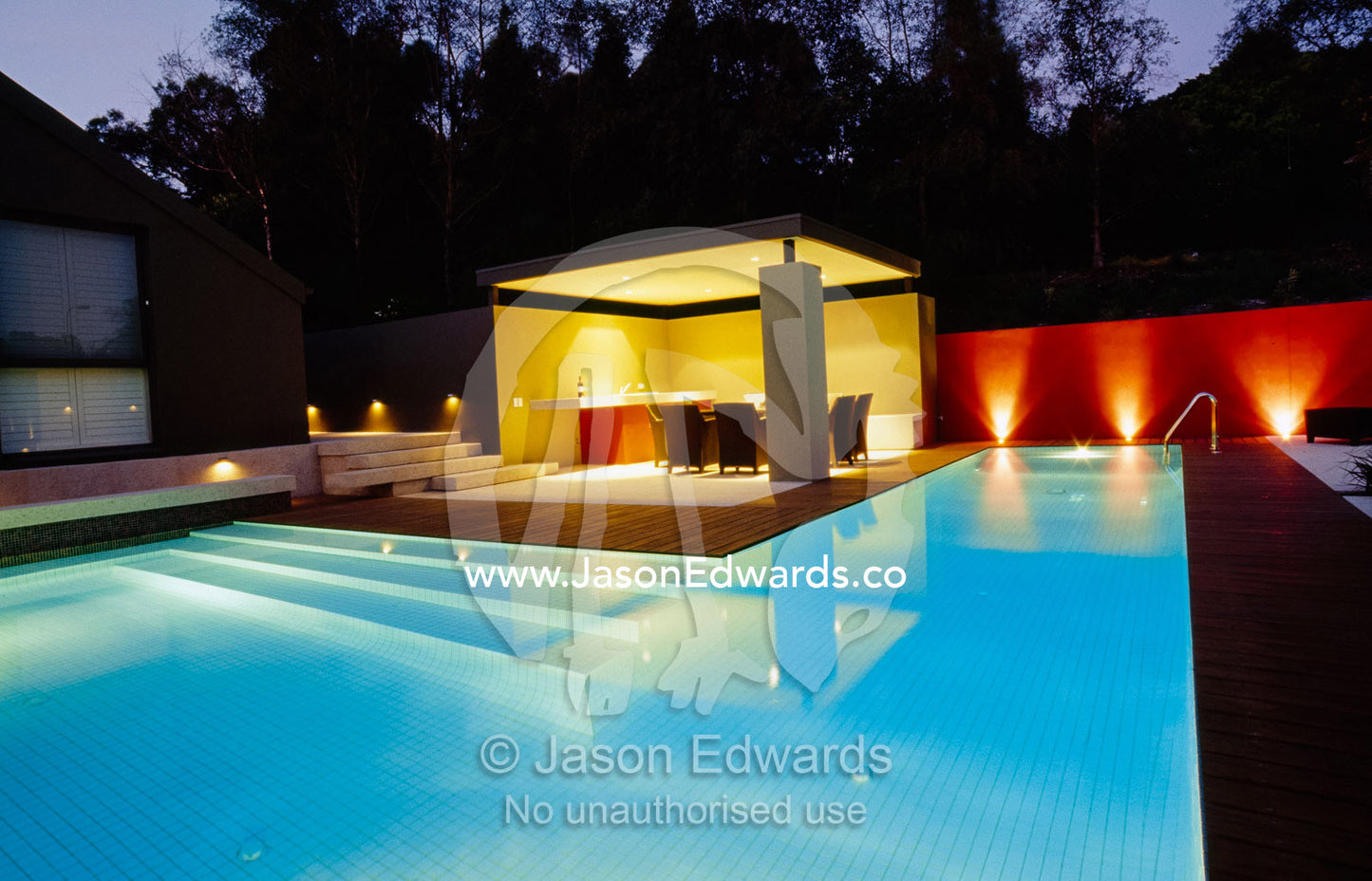 An elegant modern backyard swimming pool lit at night. Warrandyle, Victoria, Australia.