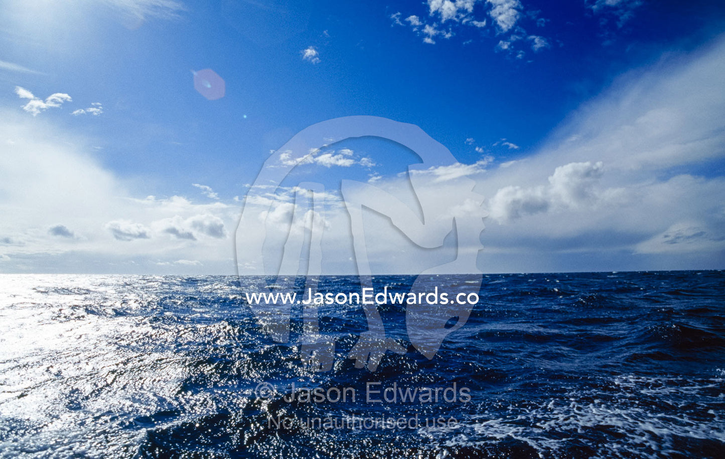 Storm clouds and sunlight reflecting off a turbulent ocean. Twofold Bay, Eden, New South Wales, Australia.