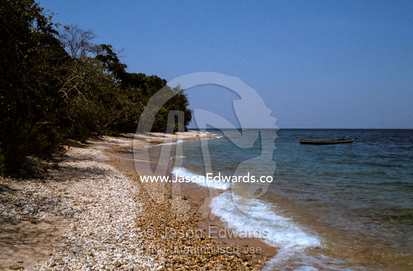 A fisherman's boat rests by the pebbled shore of Lake Tanganyika. Lake Tanganyika, Gombe Stream National Park Tanzania