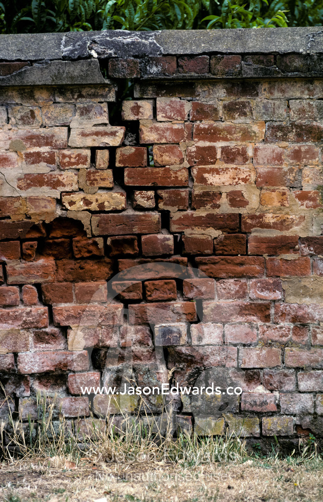 A large crack runs through an antique brick wall on a Tasmanian farm. Woodhall Farm, Perth Tasmania Australia.