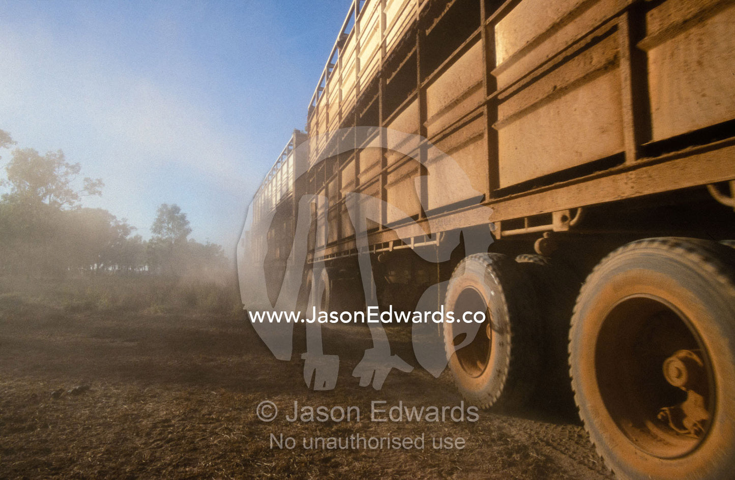 The wheels of a longhall road train churn up the dust in the outback. Epping Forest Station, Queensland, Australia.