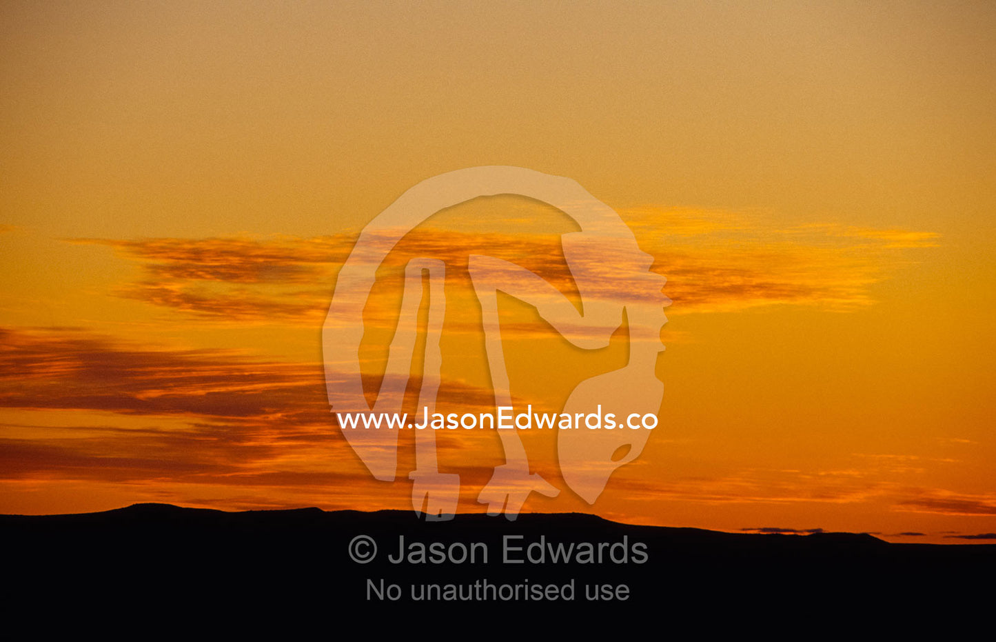 A remote golden yellow desert sunset over parallel sand dunes. Simpson Desert Regional Reserve, South Australia.