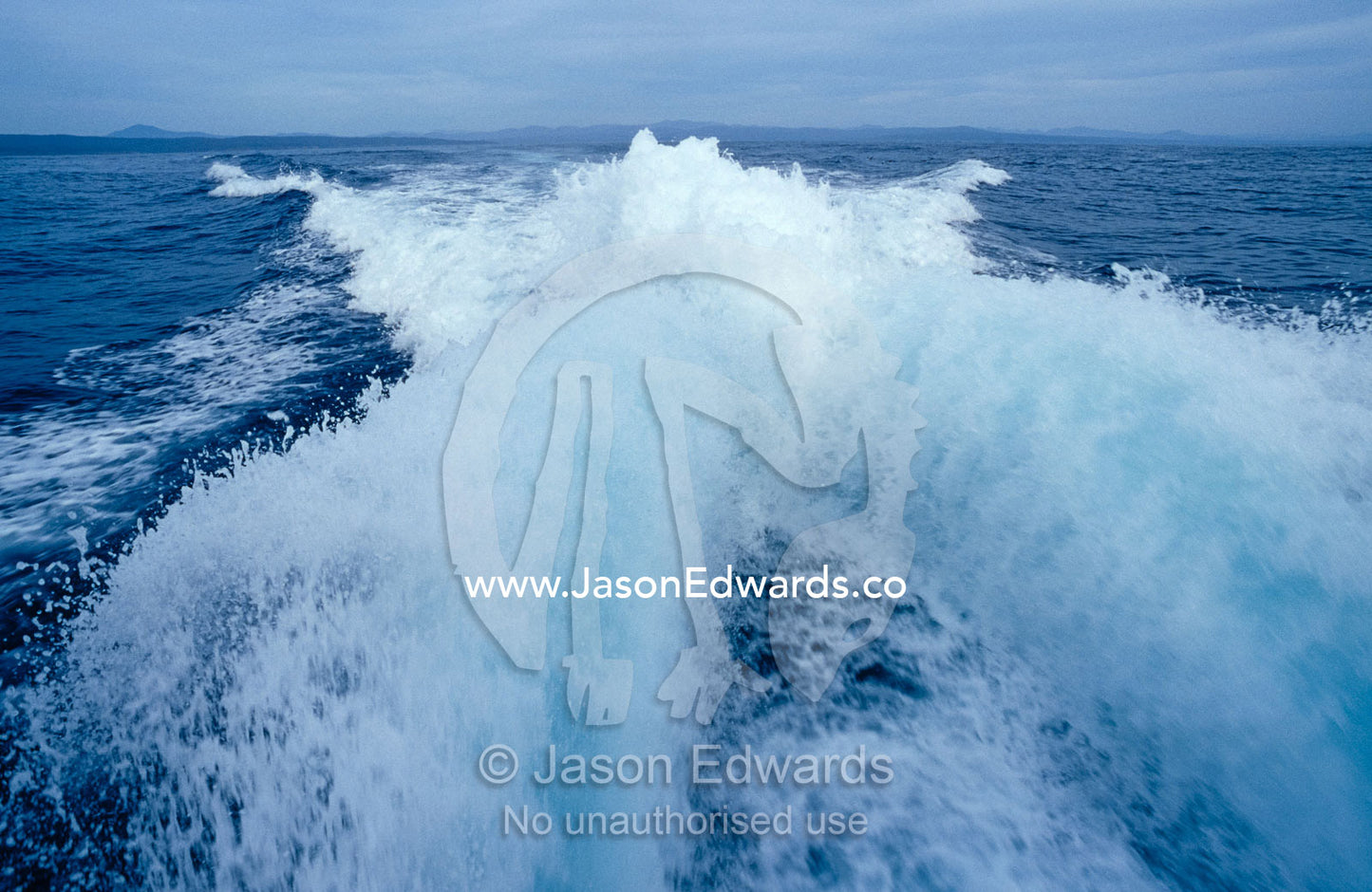 The powerful wake from a motorised boat as it heads out to sea. Twofold Bay, Eden, New South Wales, Australia.