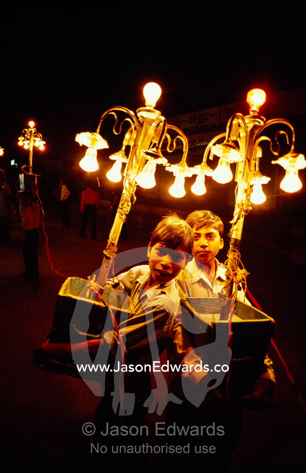 Boys carry lights for street dancing during a Hindu wedding. Sawai Madhopur, Rajasthan State, India.