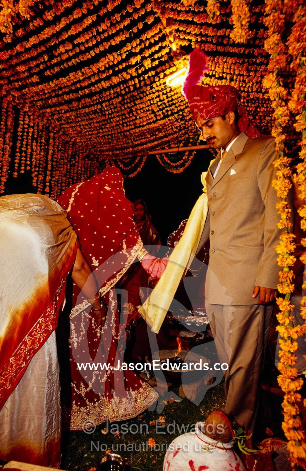 A bride leads her groom around the ceremonial fire at their wedding. Sawai Madhopur, Rajasthan State, India.