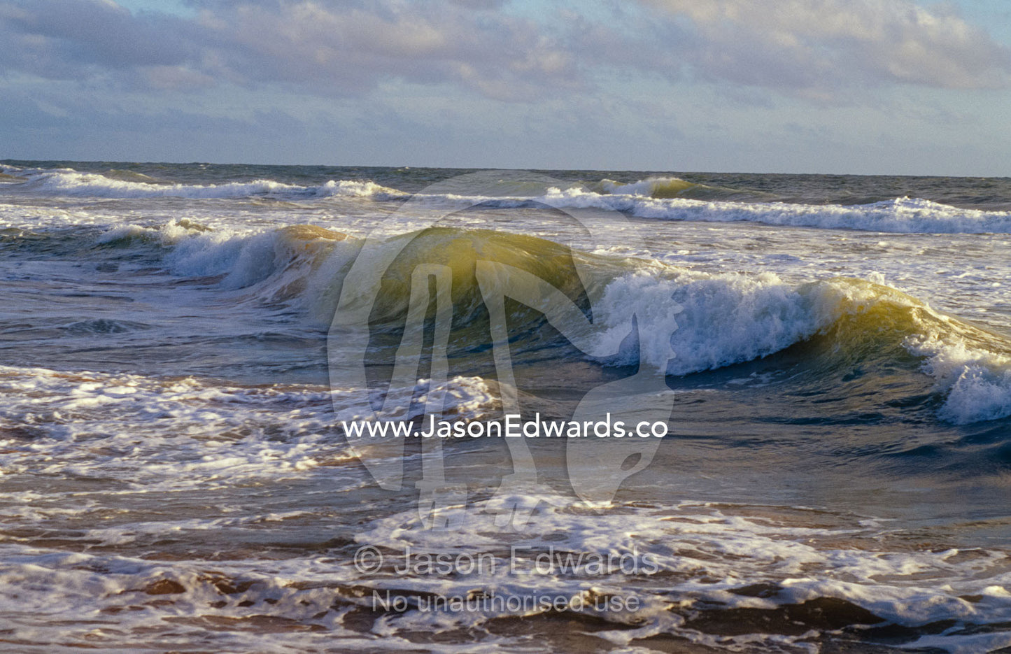 Warm seas roll onto the beach of a tropical island at sunset. Bentota Beach, Sri Lanka.