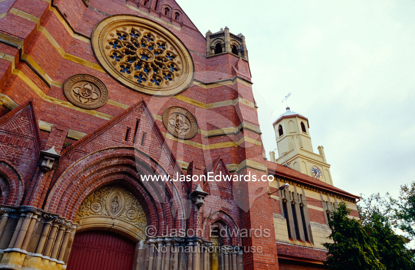 A Christian church facade with ornate brick work and heavy doors. Launceston, Tasmania, Australia.