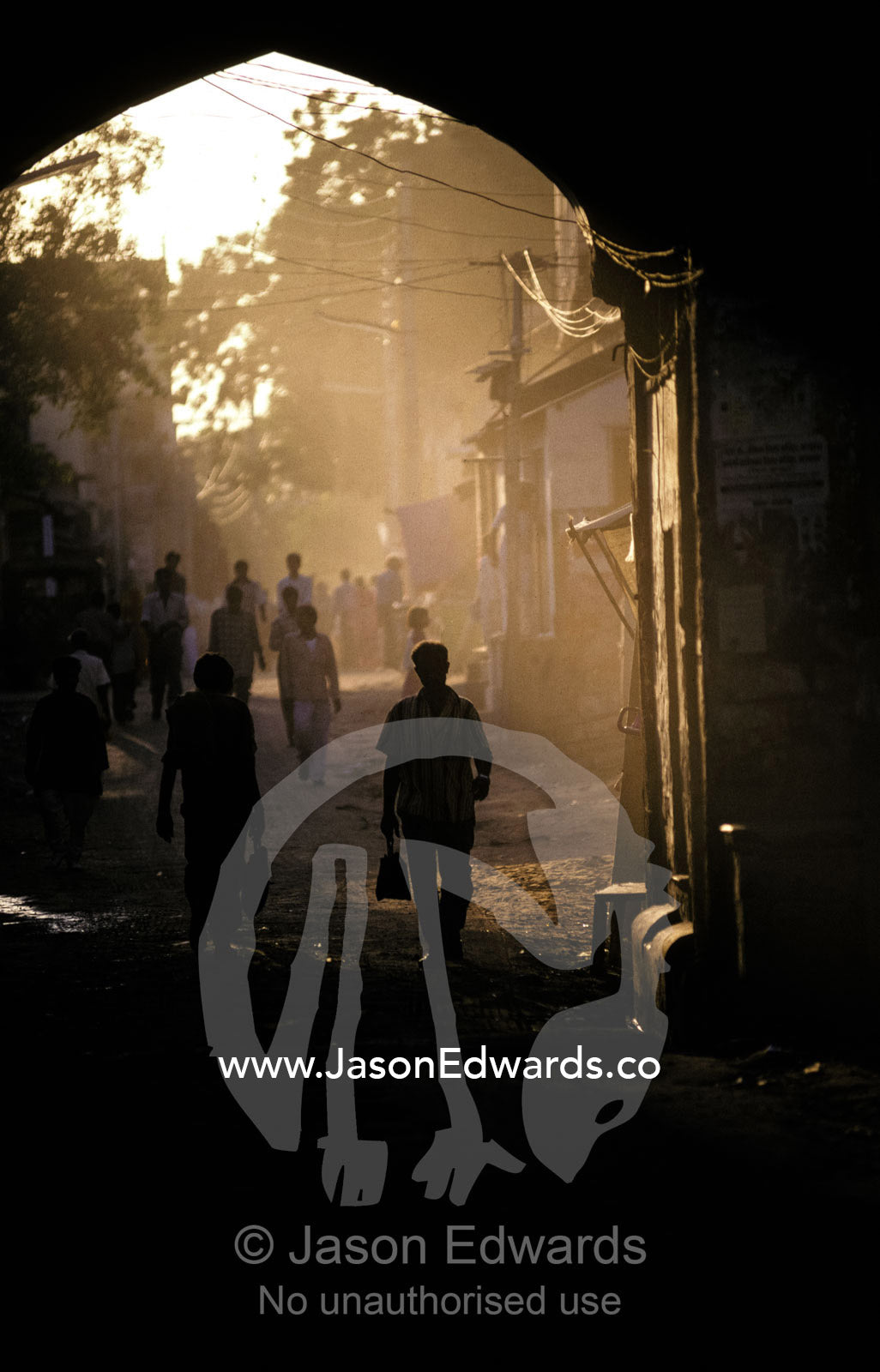 At dawn men head to work down the dusty ancient streets of Mandawa. Mandawa, Rajasthan, India.