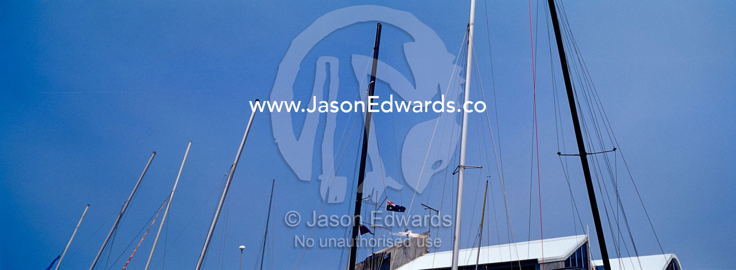 Yacht masts and rigging rise into a clear blue summer sky. Port Melbourne, Victoria, Australia.