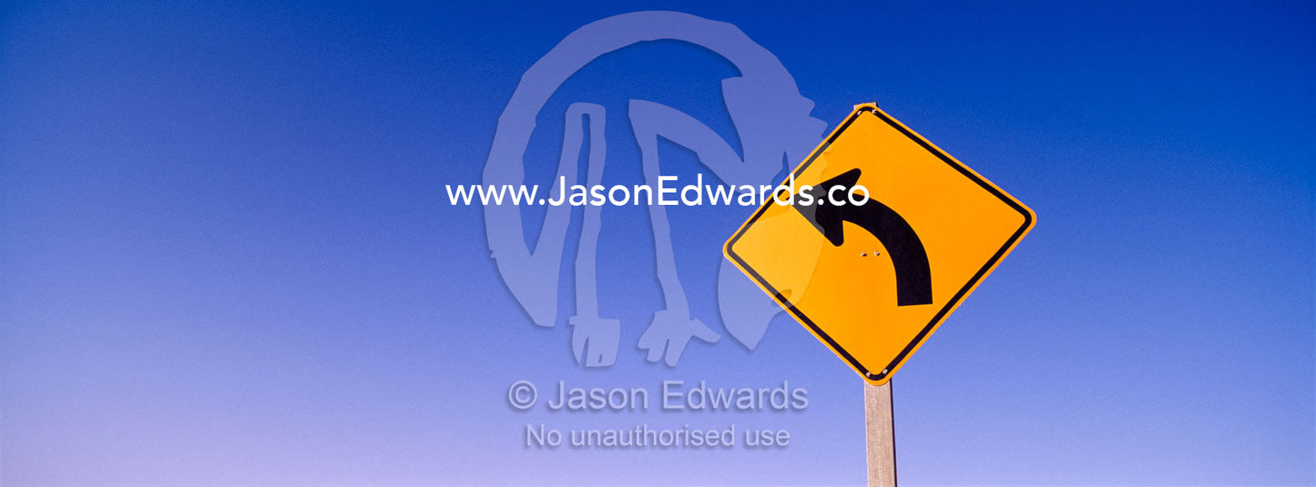 A sign warns of a rare bend in the road. near Broken Hill, New South Wales, Australia.