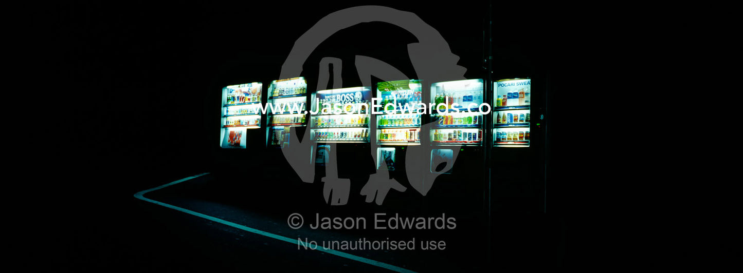 Vending machines with drinks illuminate a darkened alley at night. Shinjuku, Tokyo, Japan.