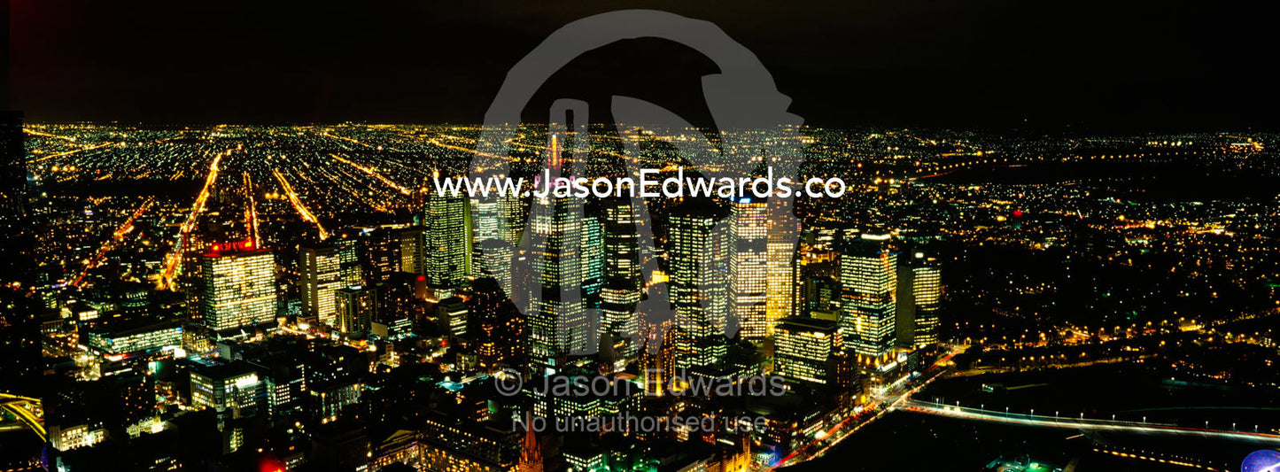 The Melbourne skyline and sprawling suburbs illuminate the night sky. Melbourne, Victoria, Australia.