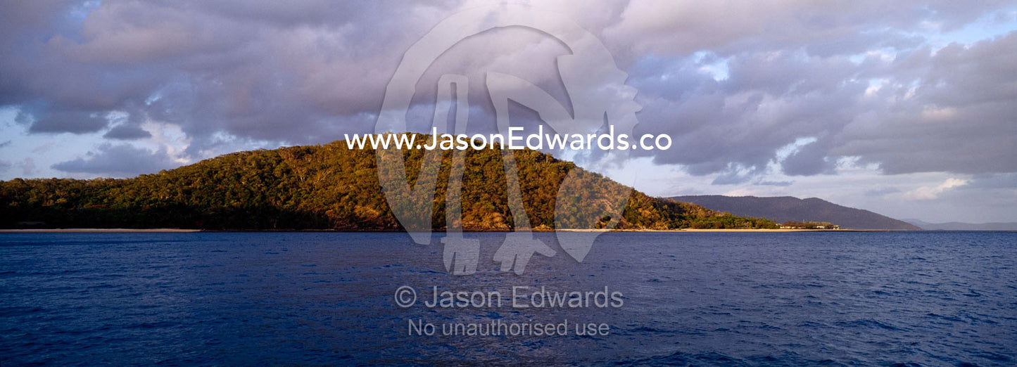 Dawn rises over remote tropical islands in the Whitsunday Passage. Whitsunday Islands, Queensland, Australia.