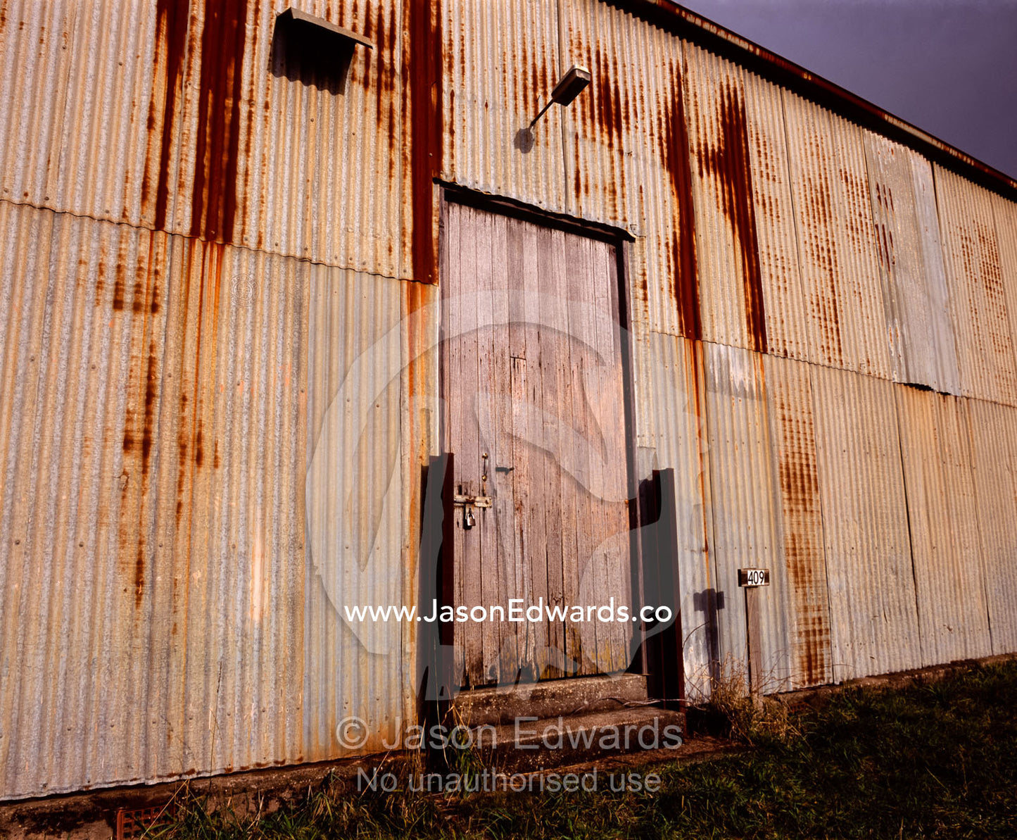 Rust eats away at a corrugated tin shed wall on a farm in Tasmania. near Ridgley, Tasmania, Australia.