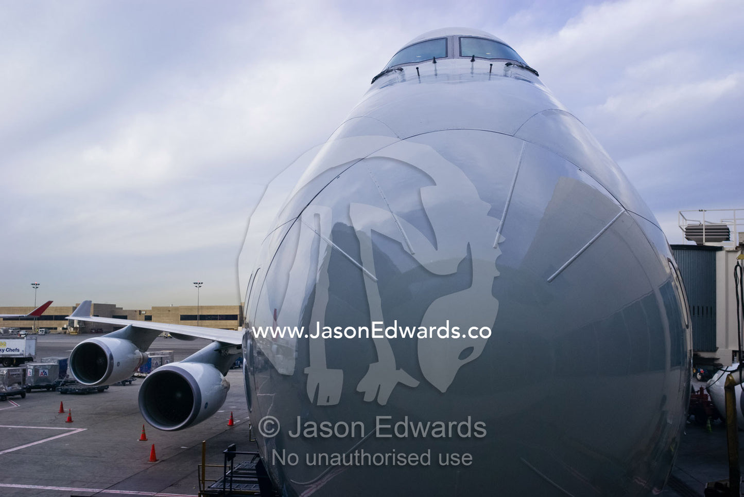 The nose cone of a massive 747 passenger aircraft rests at a terminal. Los Angeles, California, United States of America.