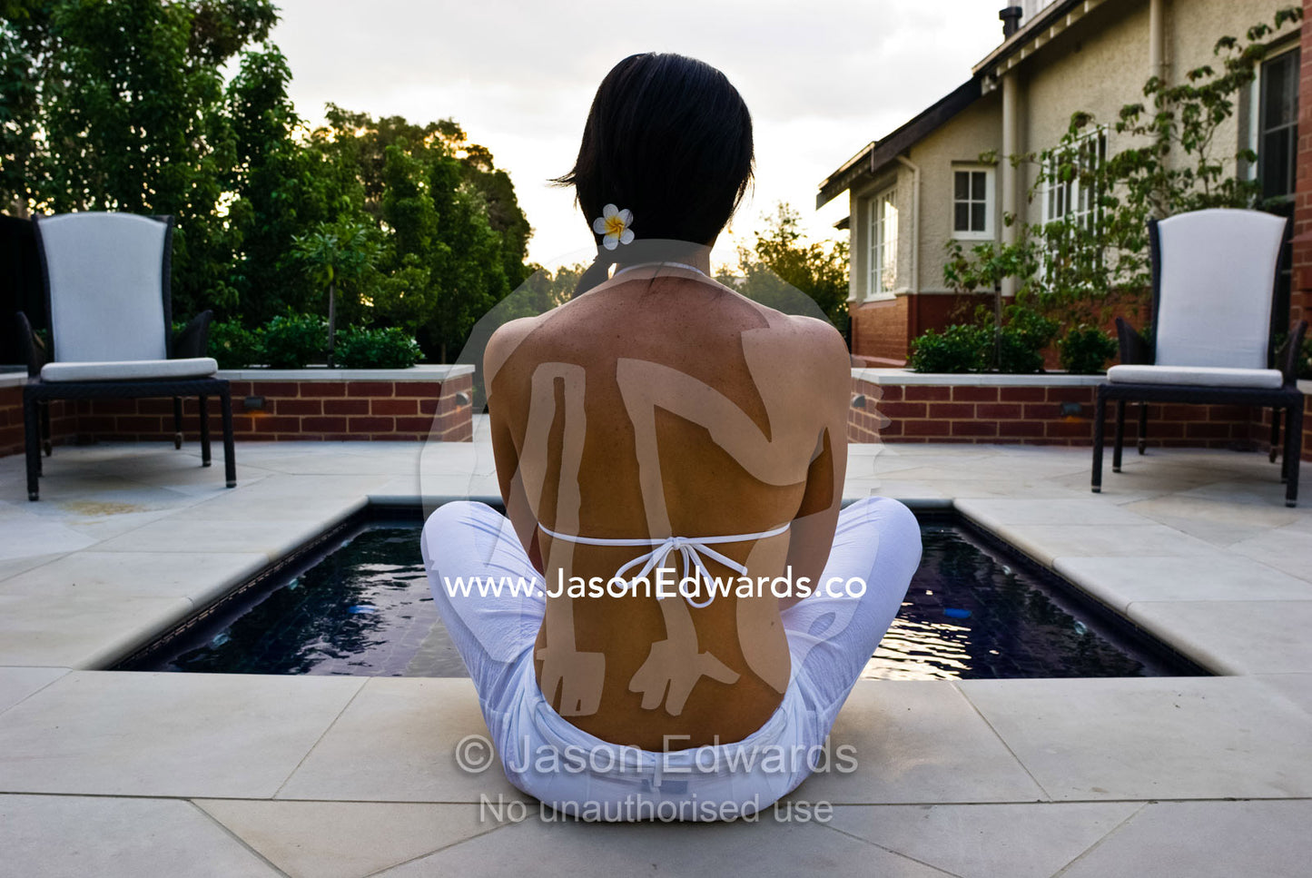 A model sits by a spa in an architecturally design suburban garden. Hawthorn, Victoria, Australia.