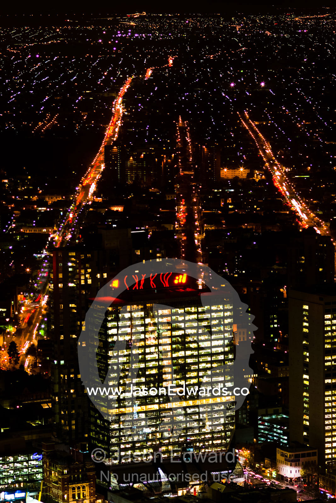 Energy hungry office towers illuminate the night sky in a major city. Melbourne, Victoria, Australia.