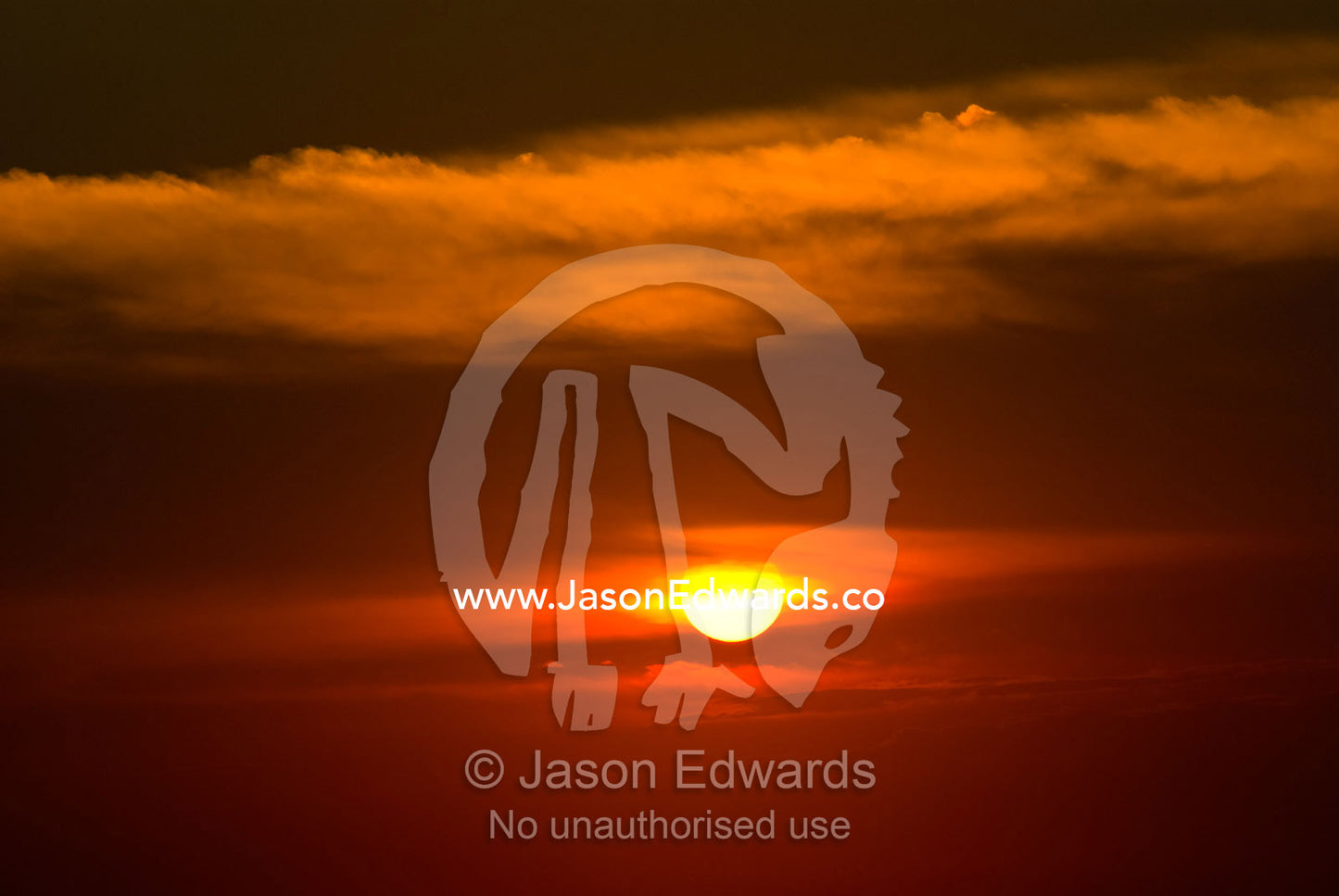 A flaming tropical island sunset over the seas of the Bali Strait. Bukit Peninsula, Bali, Indonesia.