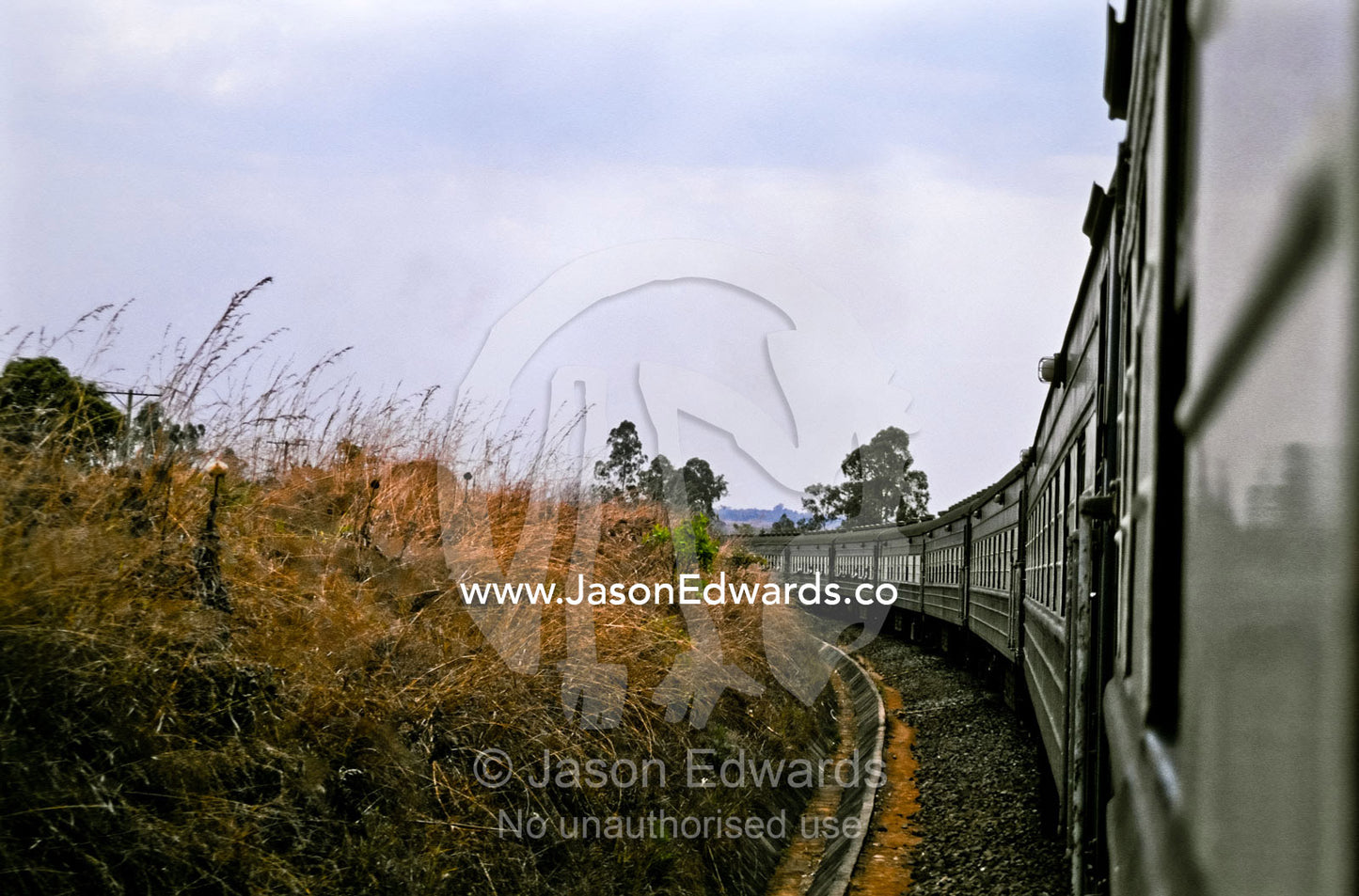 Carriages from the famous Blue Train curve around a bend in the track. Southern Tanzania.