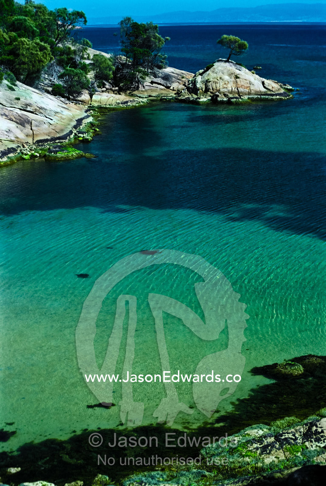 A small turquoise cove sheltered from the open waters of Oyster Bay. Great Oyster Bay, Freycinet National Park, Tasmania, Australia.