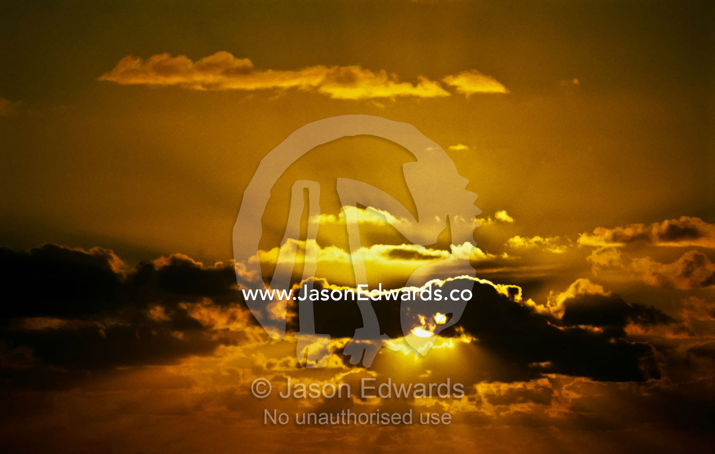 The setting sun emerges from behind a cloud bank over the Indian Ocean Scarborough Beach, Western Australia, Australia.