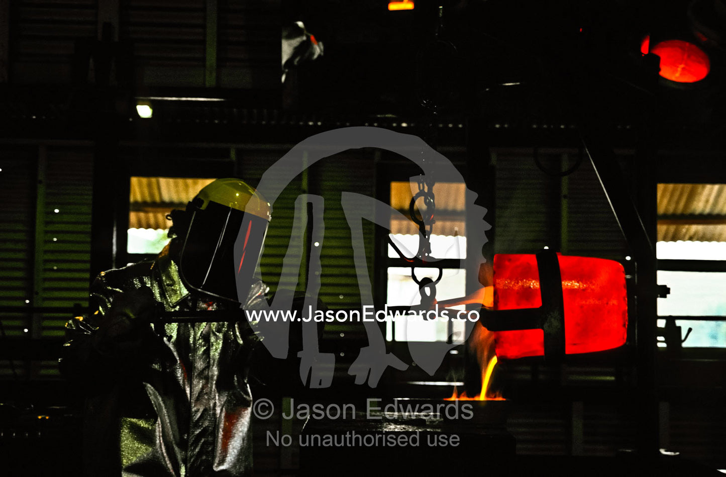 Insulated from the heat a mine worker pours molten gold into a mould. Hannan���s North Tourist Mine, Kalgoorlie-Boulder, Western Australia, Australia.