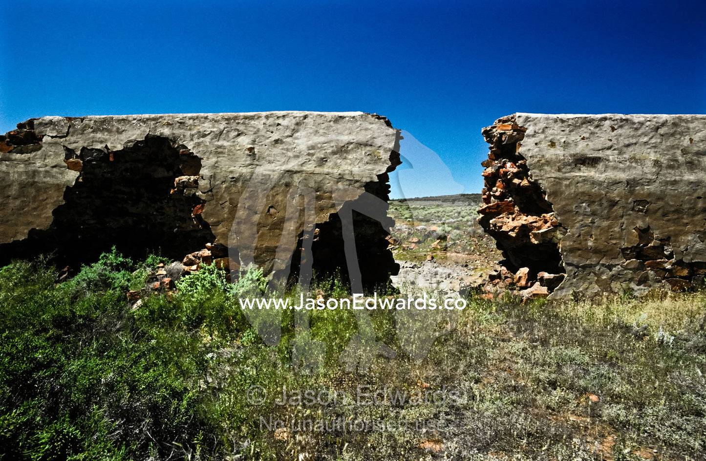 Desert floodwaters demolish a hole in a nineteenth century dam wall. Gawler Ranges National Park, South Australia, Australia.