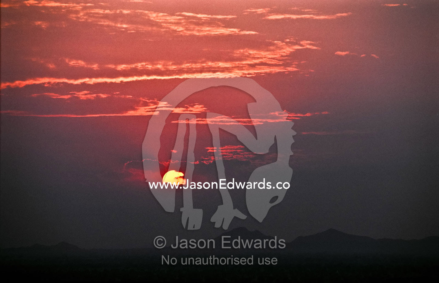 Sunset over the Aravalli Range and the smoke and dust filled plain. Samode, Jaipur, Rajasthan, India.