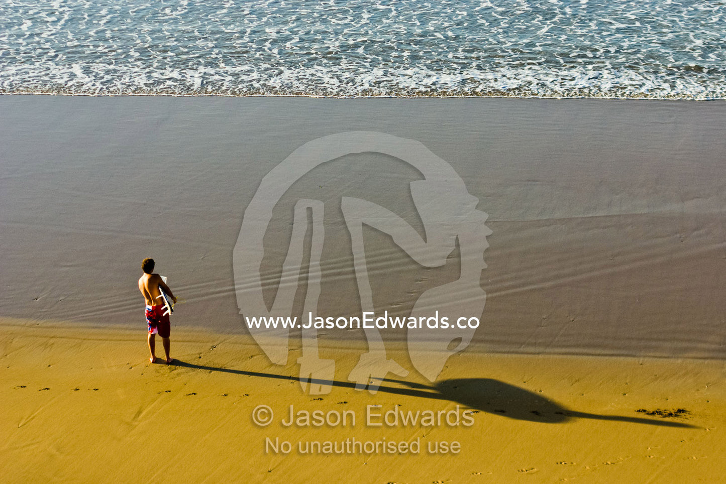 A lone surfer studies the morning swell deciding where to catch a wave Jan Juc, Surf Coast, Victoria, Australia.