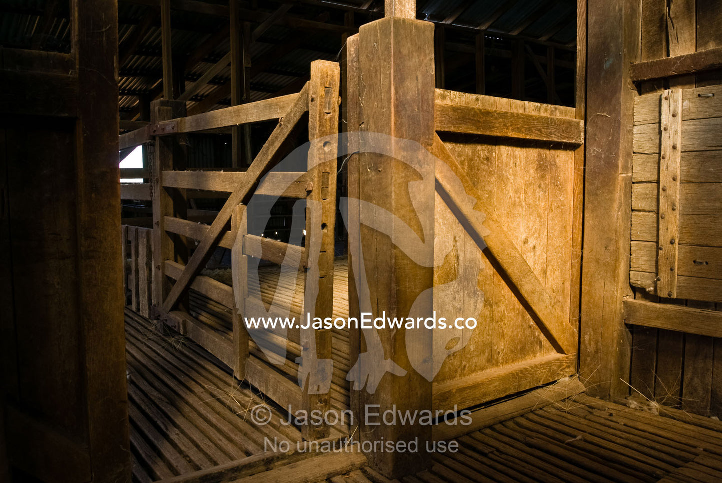 Late afternoon sun falls on a corral door in an antique shearing shed. Mundiwa Station, Deniliquin, New South Wales, Australia.