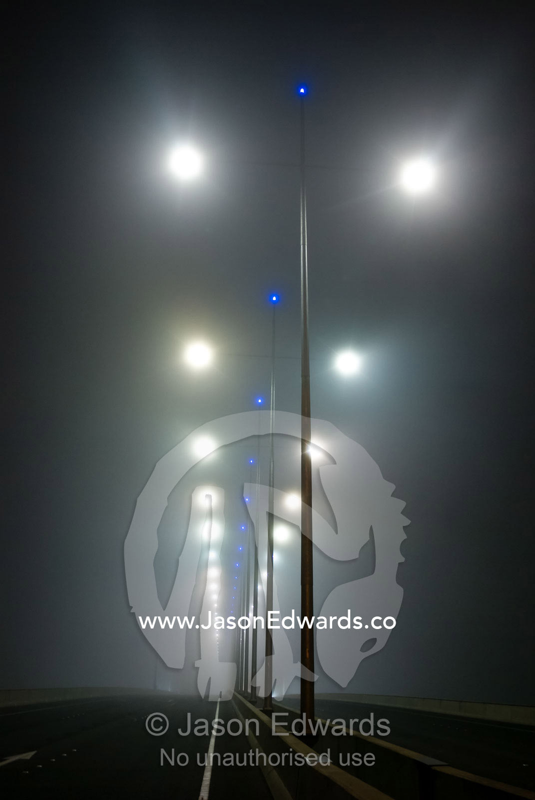 Winter fog engulfs freeway lighting on cross-town city bridge. Bolte Bridge, Yarra River, Melbourne, Victoria, Australia.