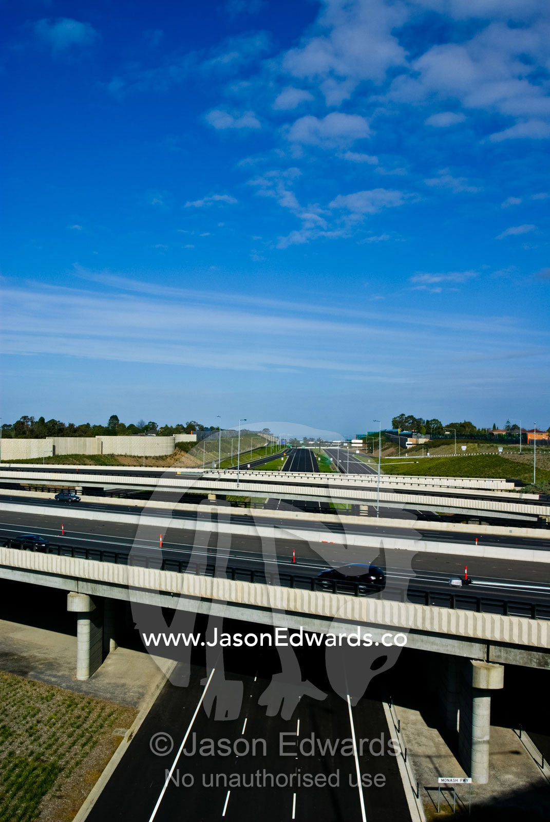 Speeding along a freeway devoid of vehicles beneath empty overpasses. Eastern and Southeastern Suburbs, Melbourne, Victoria, Australia.