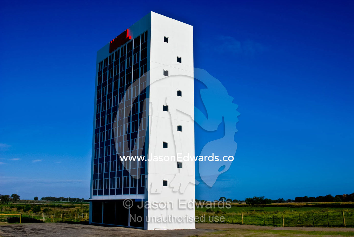 A stark white hotel that is a public art display rests in farmland. Eastern and Southeastern Suburbs, Melbourne, Victoria, Australia.