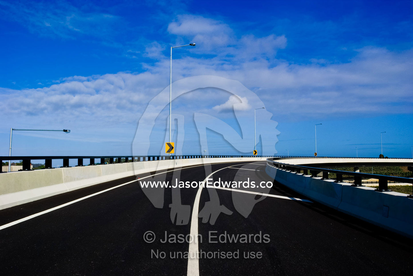 The wide curving lines of a new ultramodern freeway exit ramp. Eastern and Southeastern Suburbs, Melbourne, Victoria, Australia.