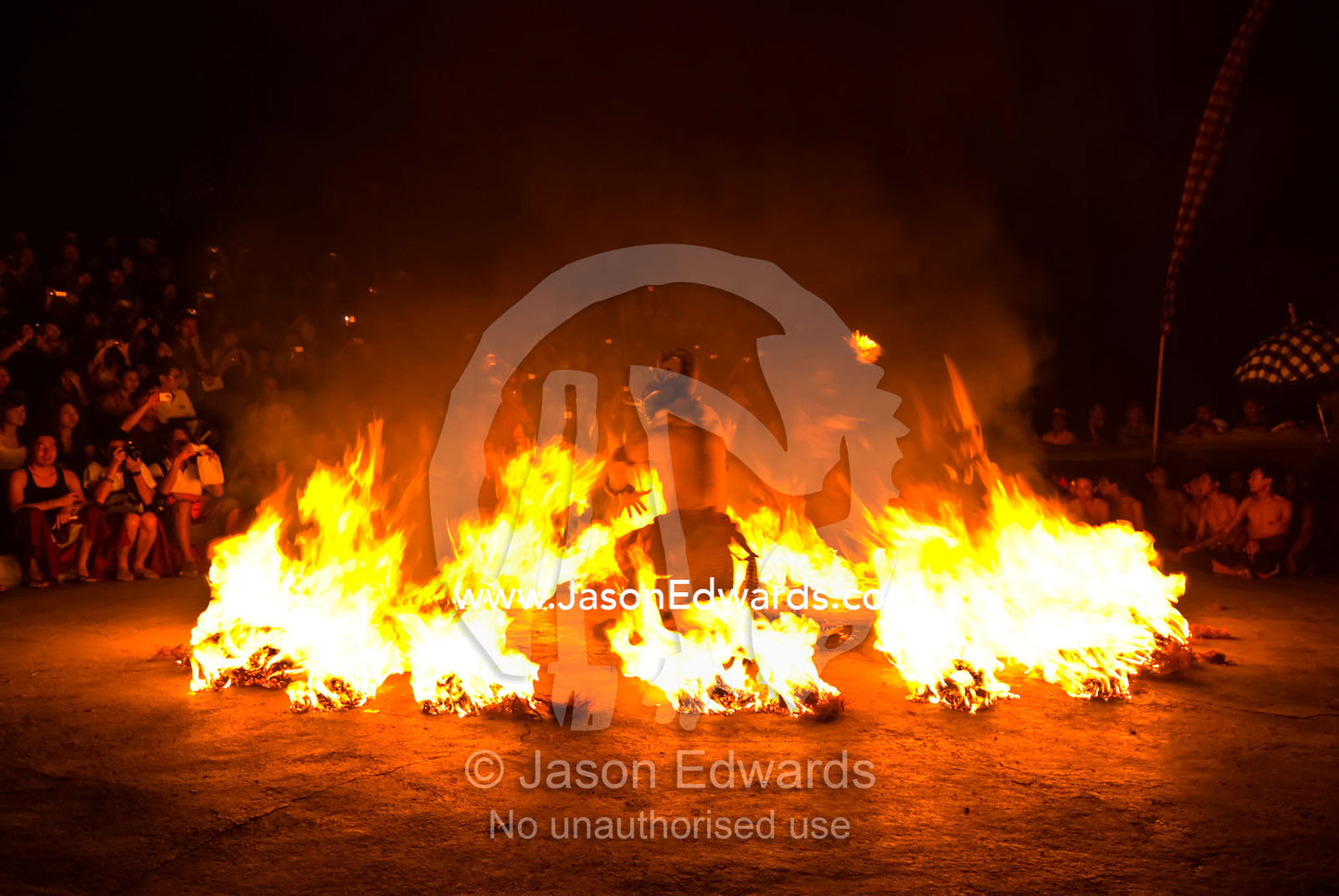 A performer in a Kecak Monkey Dance is trapped by a circle of fire. Pura Luhur Temple, Uluwatu, Badung Regency, Bali, Indonesia.