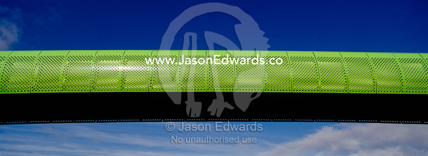 A funky lime green pedestrian footbridge spans an empty sky. Eastern and Southeastern Suburbs, Melbourne, Victoria, Australia.
