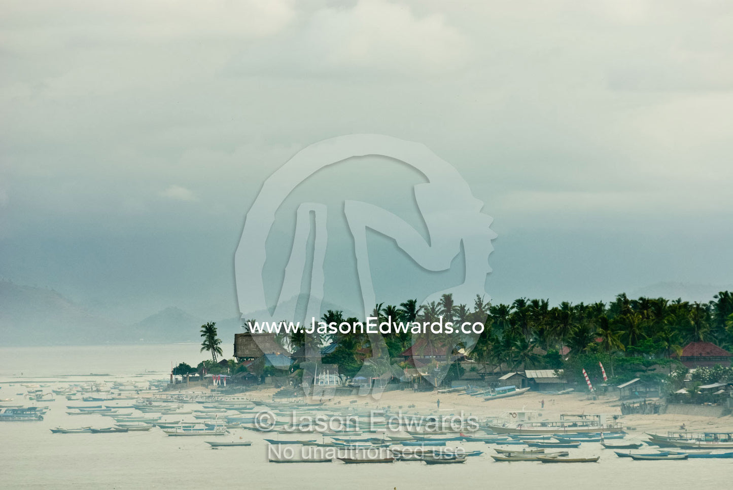 Dawn pierces a small island fishing village shrouded in cooking smoke. Nusa Lembongan Island, Bali, Indonesia.