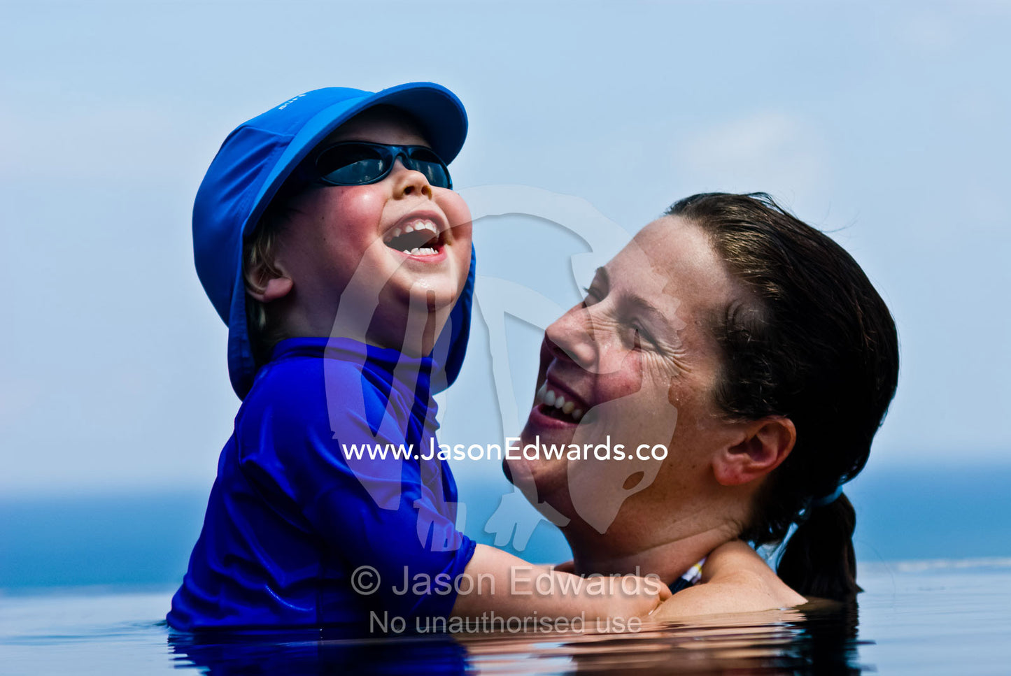 A mother and son having a wonderful time in a tropical swimming pool. Bingin, Bali, Indonesia.