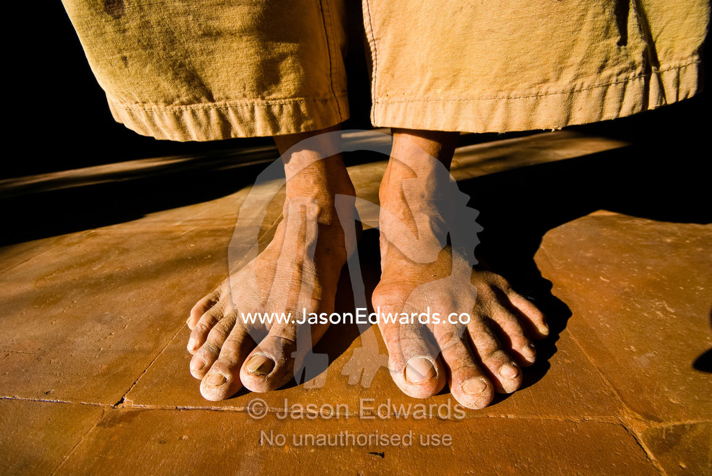 The weathered and worn feet of a laborer constructing a villa. The Temple Lodge, Bukit Peninsula, Bali, Indonesia.
