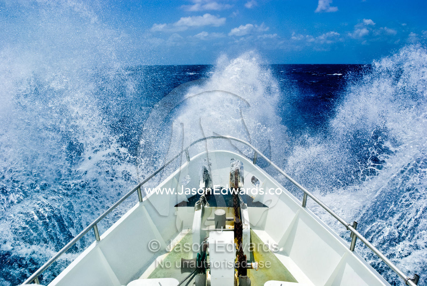 The bow of a ship ploughs through heavy seas and spray in open ocean. Coral Sea Islands Territory, Australia.