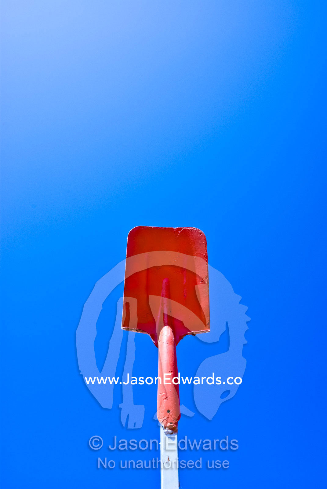 In a public art display a bright red spade rises into the desert sky. near Euriowie, outback western New South Wales, Australia.