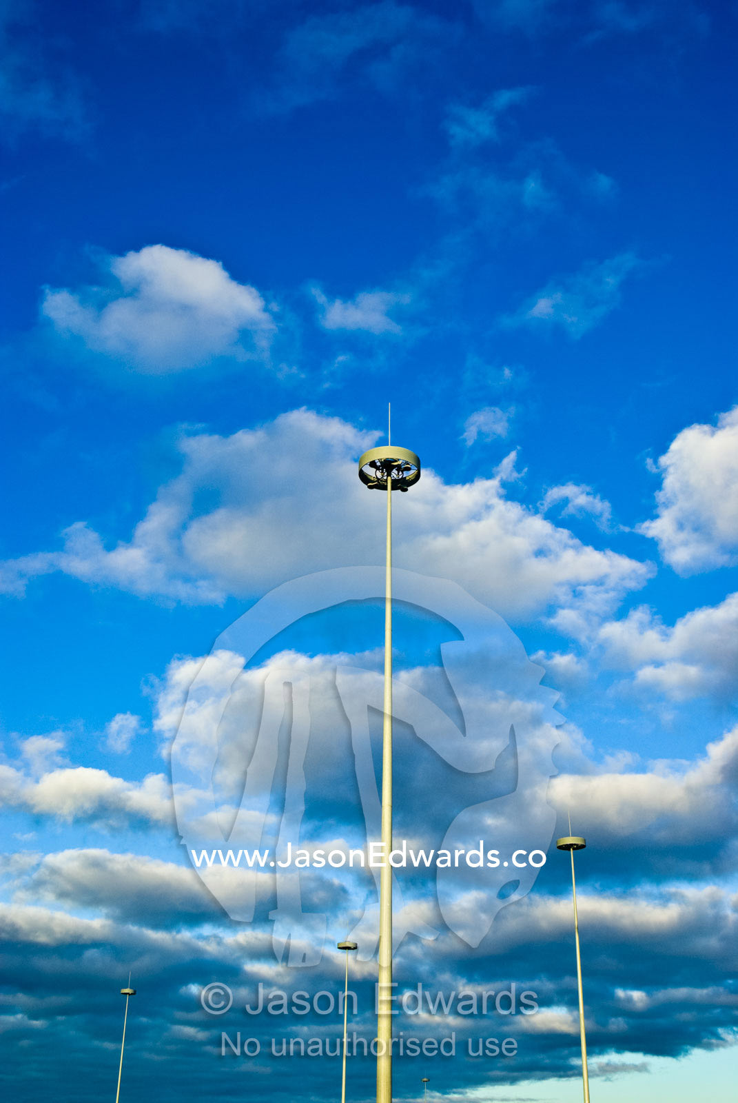 Modern needle-like highway lighting rising into a cloud-filled sky. West Gate Freeway and Princes Freeway Interchange, Laverton, Victoria, Australia