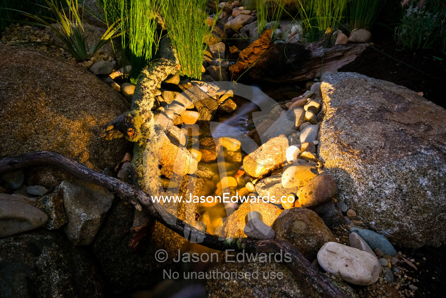 Ornamental lighting illuminates a small pebbled stream in a garden. Melbourne International Flower and Garden Show 2009, Carlton Gardens, Melbourne, Victoria, Australia