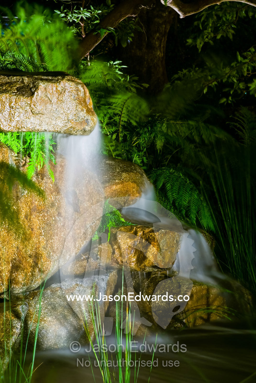 Ornamental lighting illuminates a small waterfall stream in a garden. Melbourne International Flower and Garden Show 2009, Carlton Gardens, Melbourne, Victoria, Australia