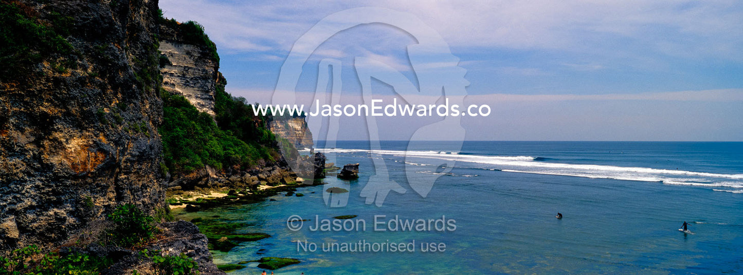 Rugged limestone cliffs overlook tranquil tropical bays and clean surf Uluwatu, Bukit Peninsula, Bali, Indonesia