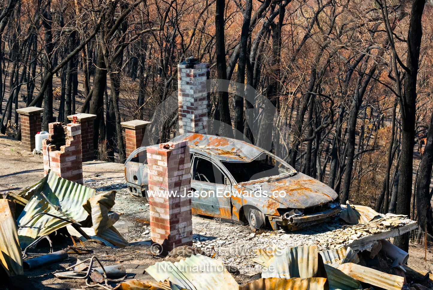 The passing of a bushfire leaves the charred remains of a home and car Near Humevale, Kinglake National Park, Victoria, Australia