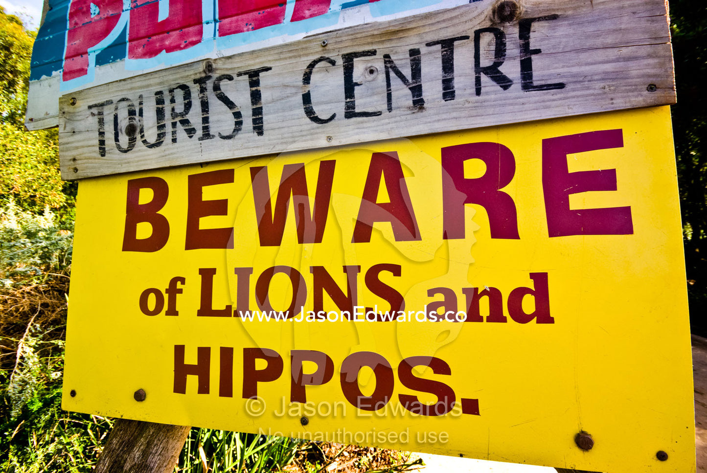 A colorful sign warns tourists of danger from lions and hippopotamus. Werribee Open Range Zoo, Werribee, Victoria, Australia