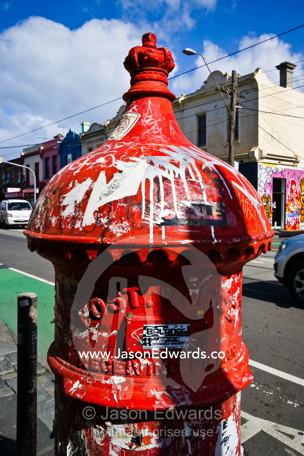 An old English mailbox covered in graffiti and illegal advertising. Brunswick Street, Fitzroy, Victoria, Australia