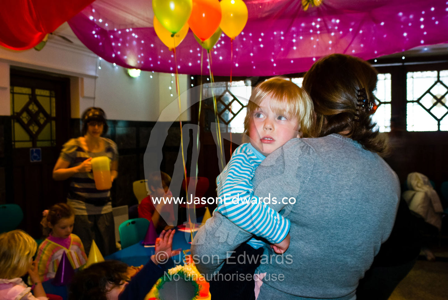 An apprehensive young boy joins a birthday party in a play center. Hawthorn, Victoria, Australia